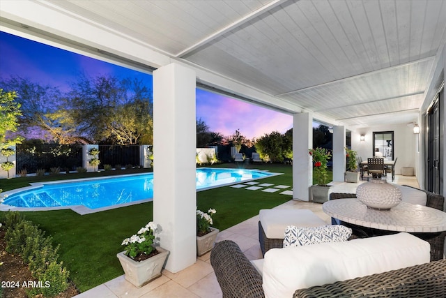 pool at dusk featuring a patio