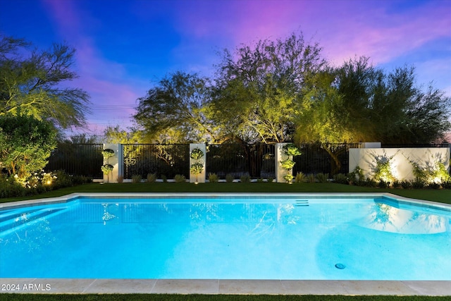 view of pool at dusk