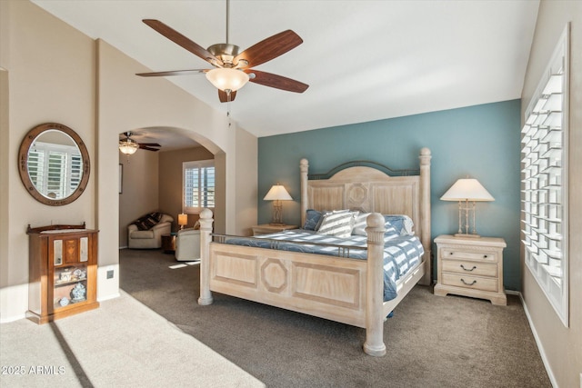 bedroom with vaulted ceiling, dark carpet, and ceiling fan