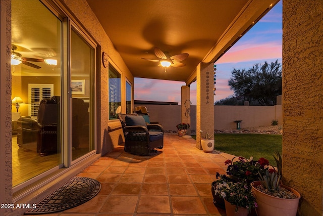 patio terrace at dusk featuring ceiling fan