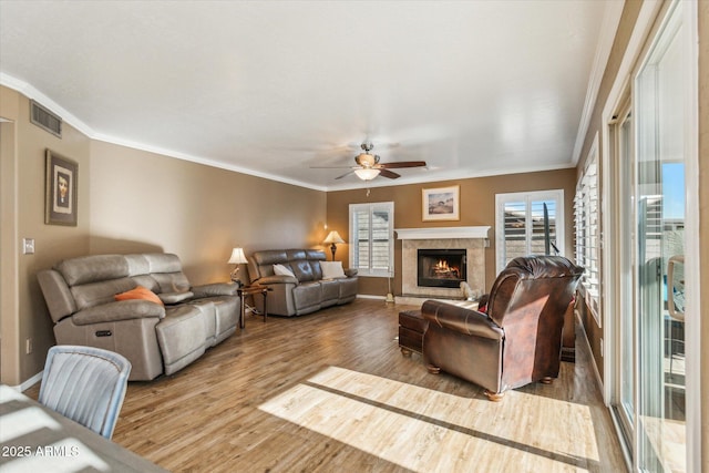 living room featuring ceiling fan, light hardwood / wood-style flooring, and crown molding