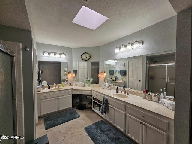 bathroom featuring a skylight, tile patterned flooring, an enclosed shower, and a textured ceiling