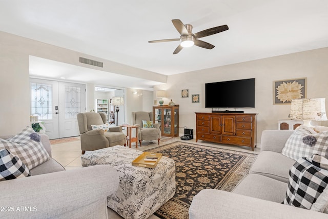 tiled living room with french doors and ceiling fan