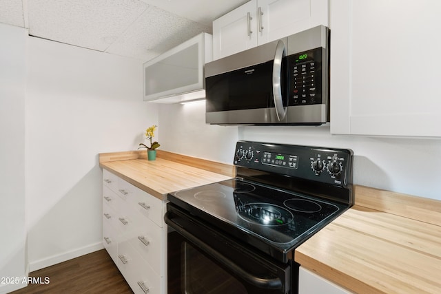 805 N 4th Ave Unit 701, Phoenix, AZ 85003 - kitchen with stainless steel microwave, black electric range, wood counters, white cabinets, and a paneled ceiling