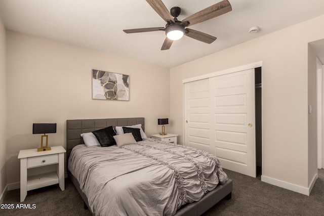 bedroom with a closet, baseboards, dark carpet, and a ceiling fan