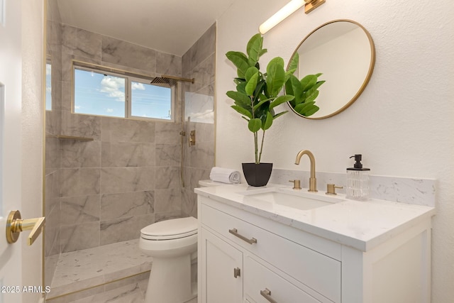 full bathroom with marble finish floor, toilet, vanity, and a tile shower