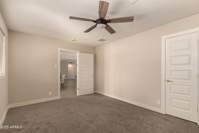 unfurnished bedroom featuring baseboards, visible vents, carpet flooring, and a ceiling fan