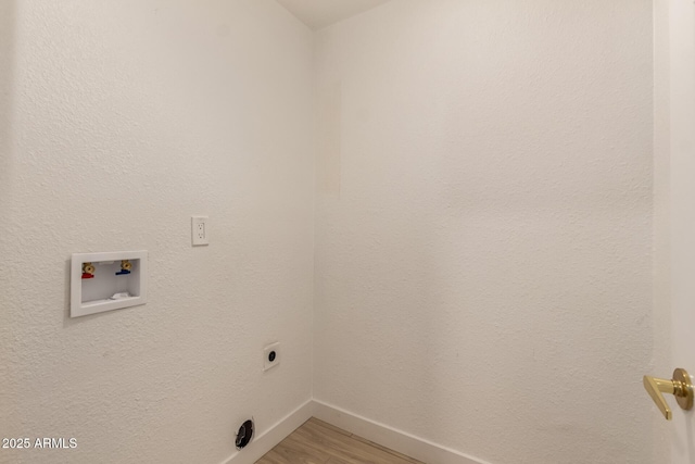 clothes washing area with light wood finished floors, washer hookup, electric dryer hookup, laundry area, and baseboards