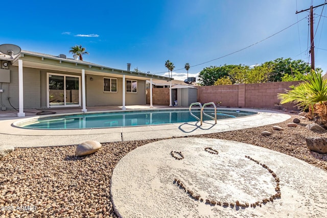 view of pool with a patio area, a fenced in pool, an outdoor structure, a storage shed, and a fenced backyard