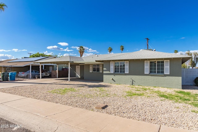 ranch-style home with driveway, a carport, fence, and brick siding