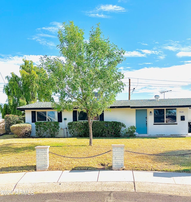 ranch-style home featuring a front lawn