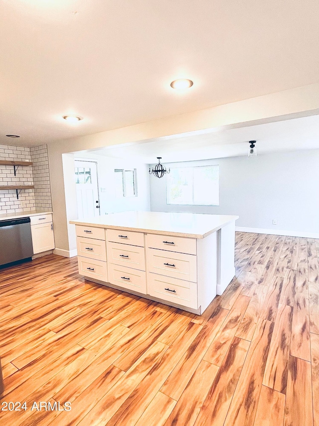 kitchen featuring stainless steel dishwasher, white cabinets, and light hardwood / wood-style floors