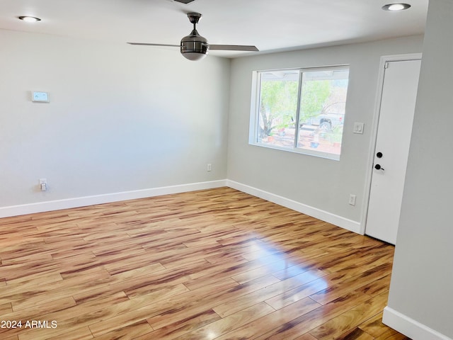 spare room with ceiling fan and light wood-type flooring