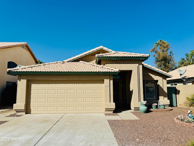 view of front of home featuring driveway, an attached garage, and stucco siding