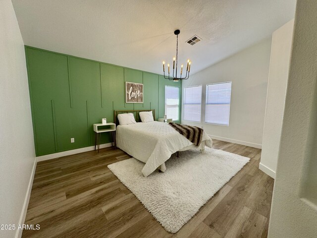 5984 W Geronimo Ct, Chandler, AZ 85226 - bedroom featuring wood finished floors, a notable chandelier, baseboards, and visible vents