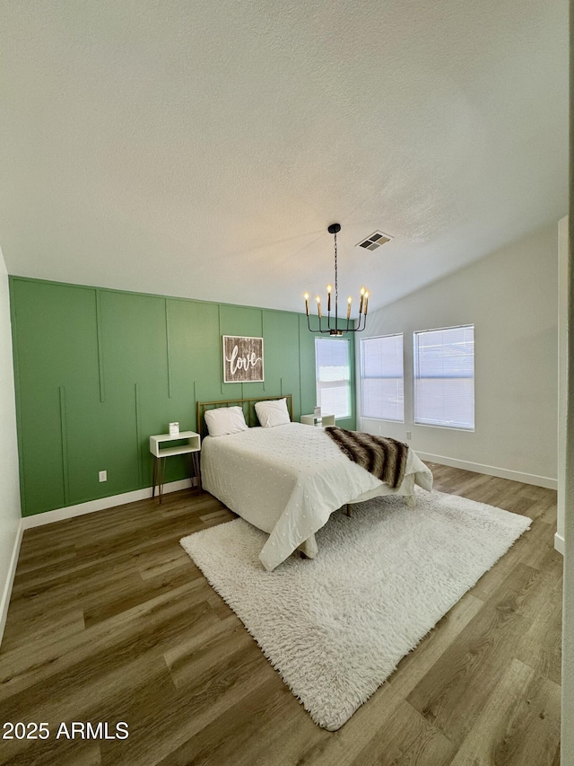 5984 W Geronimo Ct, Chandler, AZ 85226 - bedroom featuring visible vents, a textured ceiling, wood finished floors, and a notable chandelier