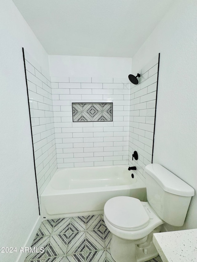 bathroom featuring toilet, tile patterned flooring, and bathing tub / shower combination