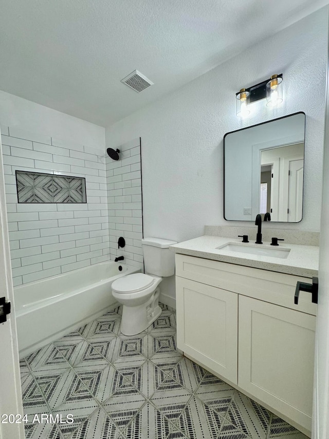 bathroom featuring a textured ceiling, toilet, vanity, visible vents, and washtub / shower combination