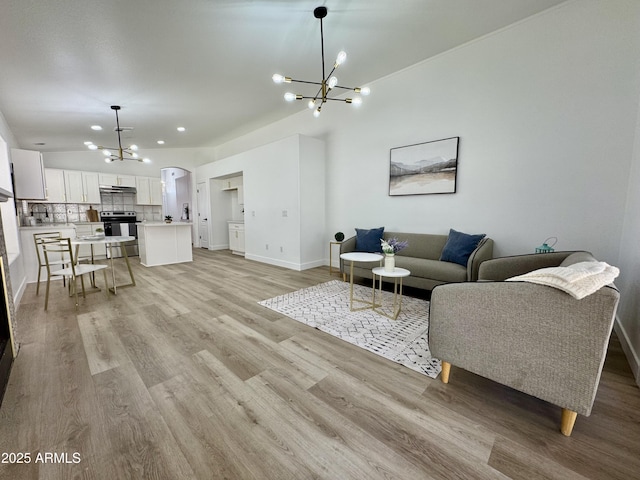5984 W Geronimo Ct, Chandler, AZ 85226 - living room featuring baseboards, a notable chandelier, light wood-style floors, and vaulted ceiling