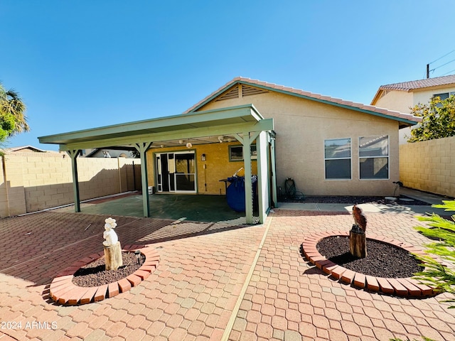 rear view of house featuring a patio area, a fenced backyard, and stucco siding