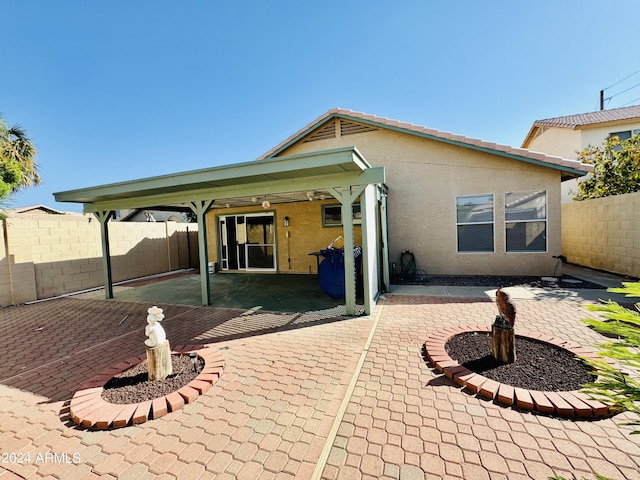 back of house with a fenced backyard, a patio, and stucco siding