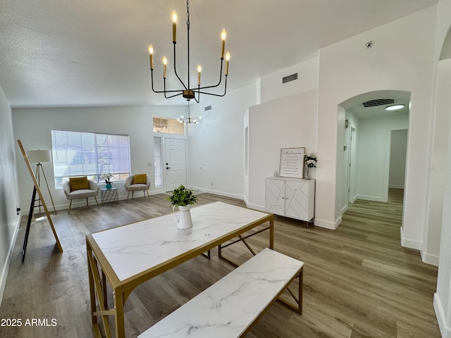 5984 W Geronimo Ct, Chandler, AZ 85226 - dining space with a chandelier, wood finished floors, baseboards, visible vents, and arched walkways