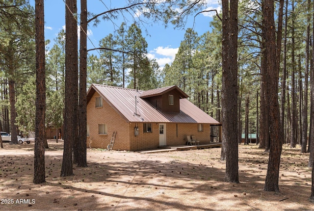 2452 Daisy Trl, Forest Lakes, AZ 85931 - view of home's exterior with dirt driveway, brick siding, and metal roof