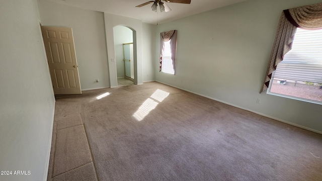 spare room with ceiling fan and light colored carpet