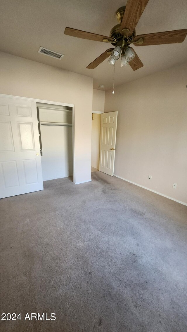 unfurnished bedroom with carpet flooring, a closet, and ceiling fan