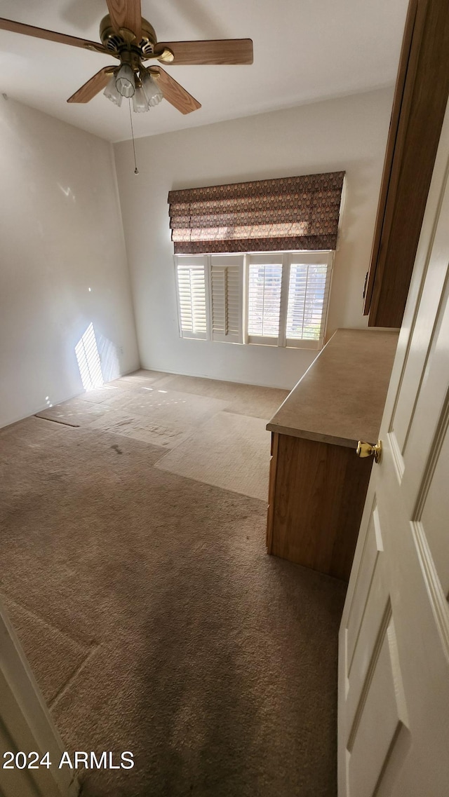 carpeted spare room with ceiling fan