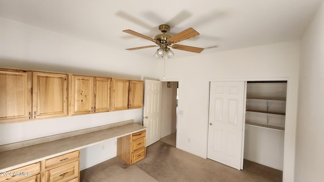 office with ceiling fan, built in desk, and dark carpet