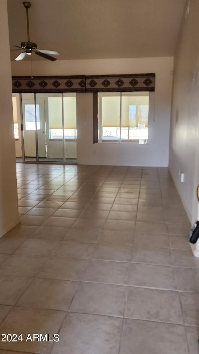 unfurnished room featuring ceiling fan, a healthy amount of sunlight, and light tile patterned floors