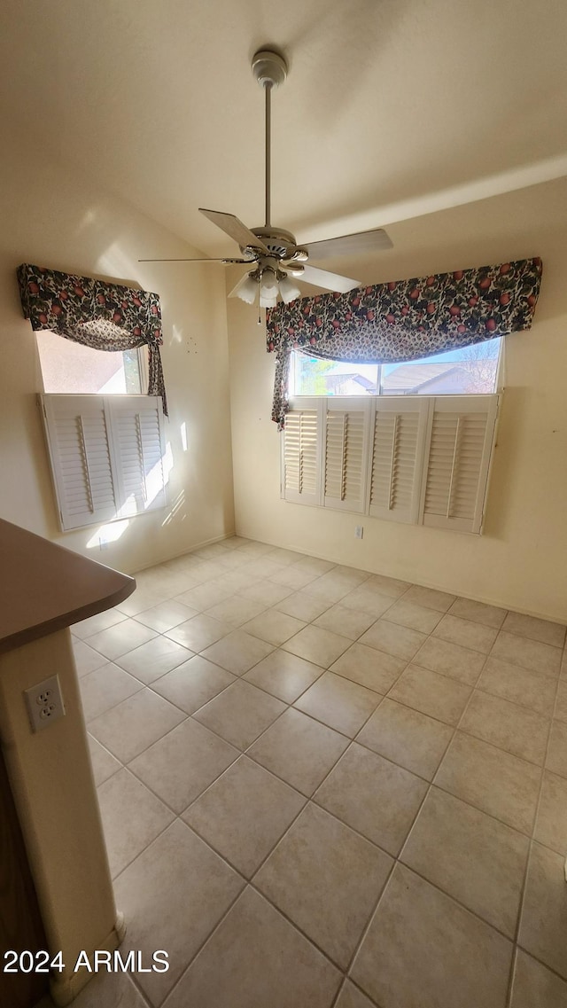 empty room with ceiling fan and light tile patterned flooring