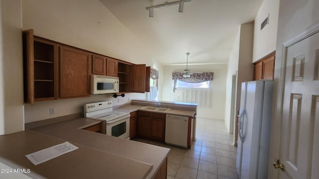 kitchen with kitchen peninsula, white appliances, hanging light fixtures, and sink