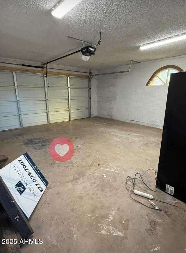 garage with concrete block wall and a garage door opener