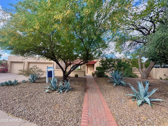 view of front of property with a garage, stucco siding, and concrete driveway