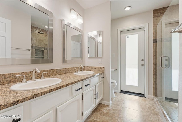 bathroom featuring toilet, a sink, and a stall shower