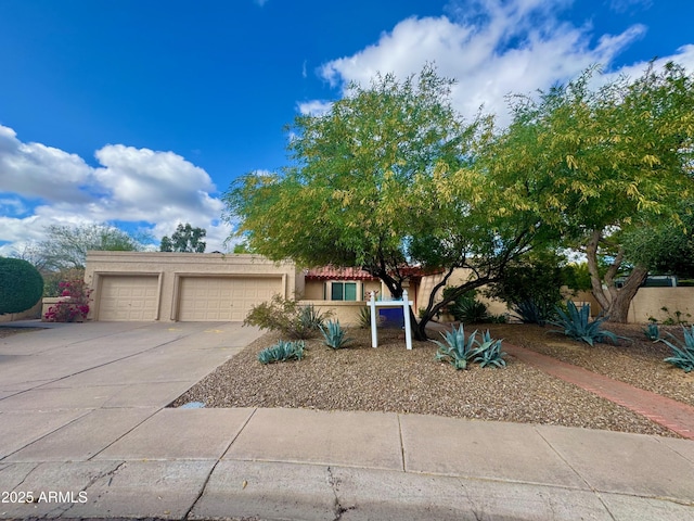 view of front of property featuring a garage, stucco siding, and driveway