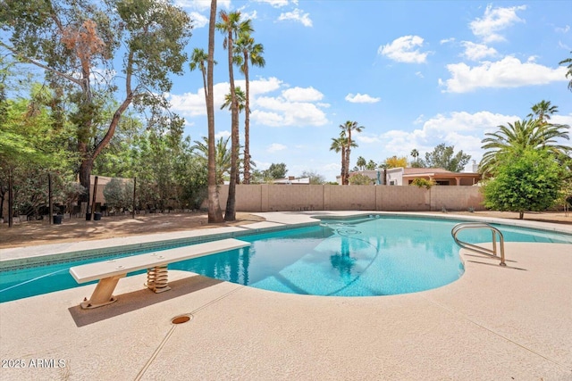 view of pool featuring fence, a fenced in pool, a patio, and a diving board
