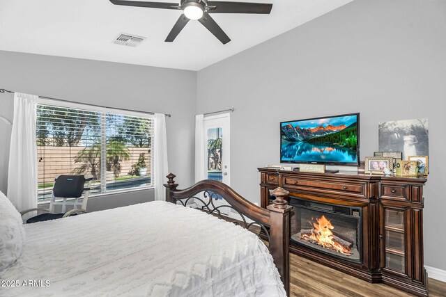 32881 N Hidden Canyon Dr, San Tan Valley, AZ 85144 - bedroom featuring visible vents, a glass covered fireplace, wood finished floors, and ceiling fan