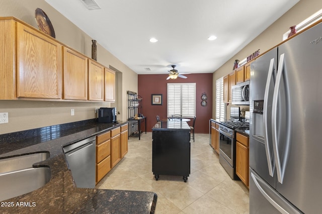 kitchen featuring visible vents, appliances with stainless steel finishes, light tile patterned flooring, ceiling fan, and a sink