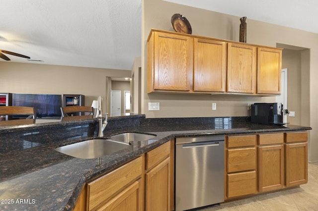 kitchen featuring ceiling fan, a sink, open floor plan, dishwasher, and dark stone countertops