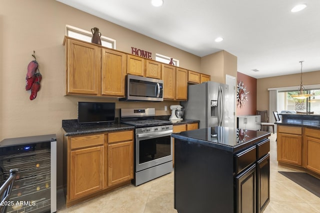 kitchen featuring wine cooler, pendant lighting, stainless steel appliances, light tile patterned flooring, and a kitchen island