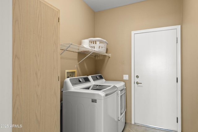 washroom featuring light tile patterned floors, laundry area, and separate washer and dryer