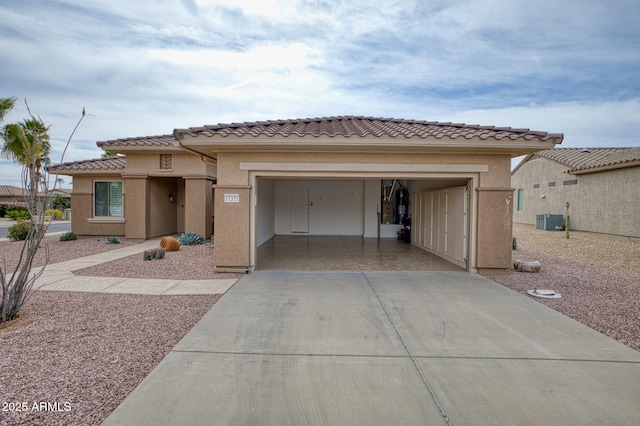 view of front of house with cooling unit, concrete driveway, an attached garage, and stucco siding