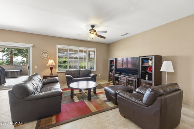 living area with light tile patterned floors, ceiling fan, and visible vents