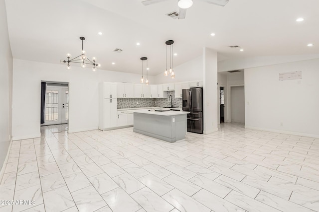 3614 W Granada Rd, Phoenix, AZ 85009 - kitchen featuring stainless steel fridge, open floor plan, vaulted ceiling, light countertops, and a kitchen island