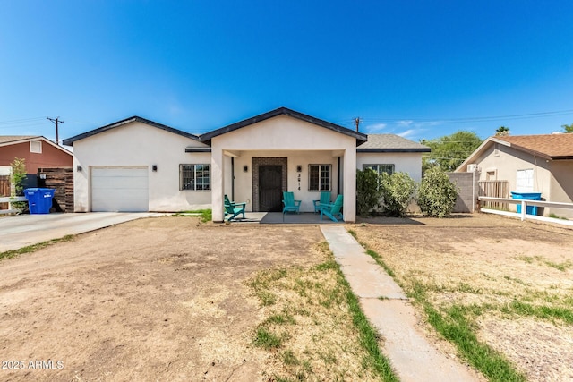 3614 W Granada Rd, Phoenix, AZ 85009 - view of front of property with an attached garage, stucco siding, covered porch, and concrete driveway