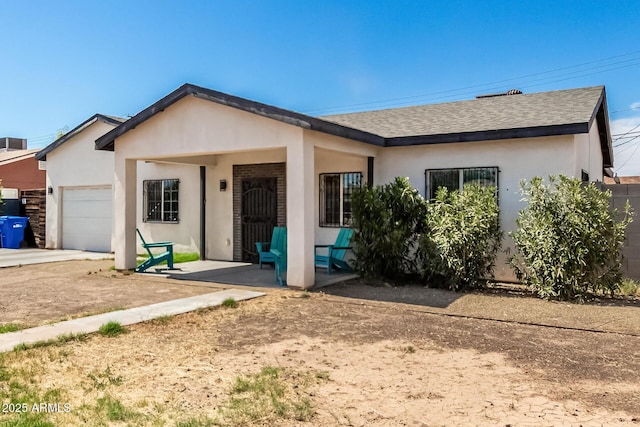 3614 W Granada Rd, Phoenix, AZ 85009 - ranch-style home with a garage, a shingled roof, and stucco siding