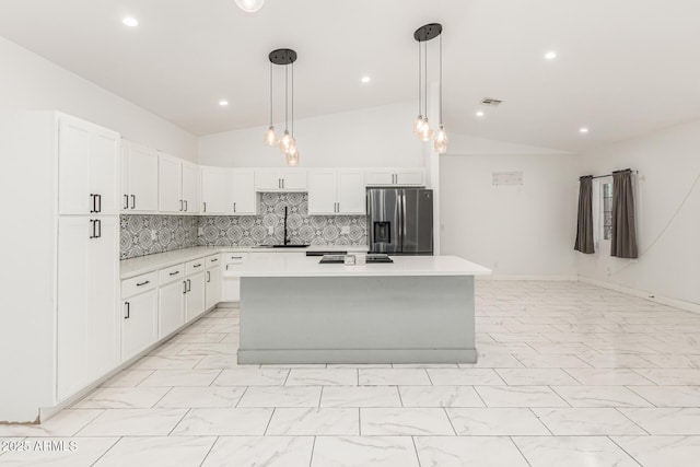 3614 W Granada Rd, Phoenix, AZ 85009 - kitchen with stainless steel refrigerator with ice dispenser, lofted ceiling, light marble finish flooring, light countertops, and a kitchen island
